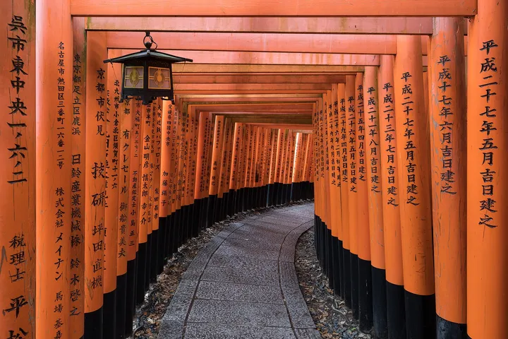 Un chemin bordé de torii rouges au sanctuaire Fushimi Inari, à Kyoto